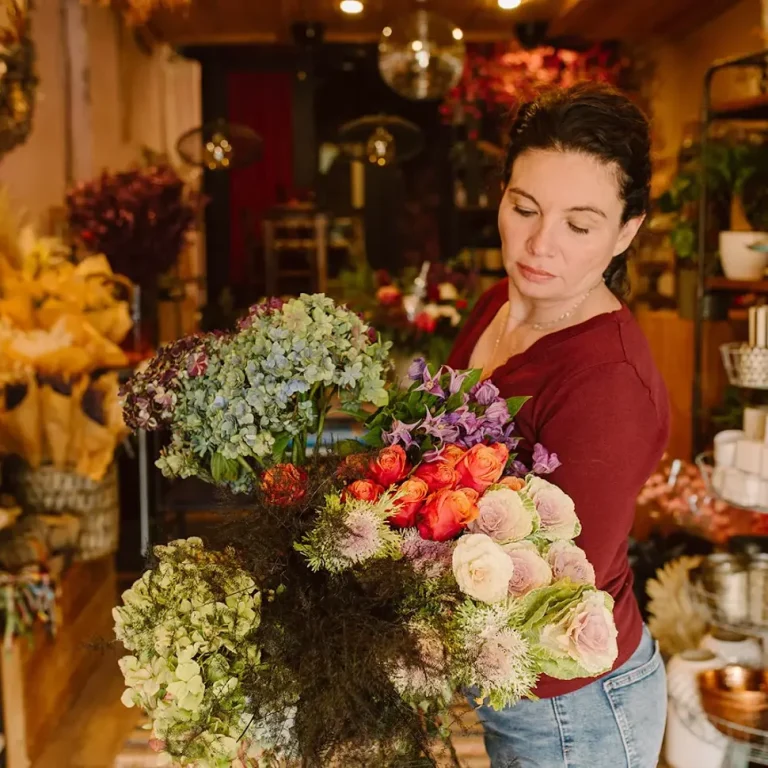 Florist arranging dark plum blooms in a velvet drape